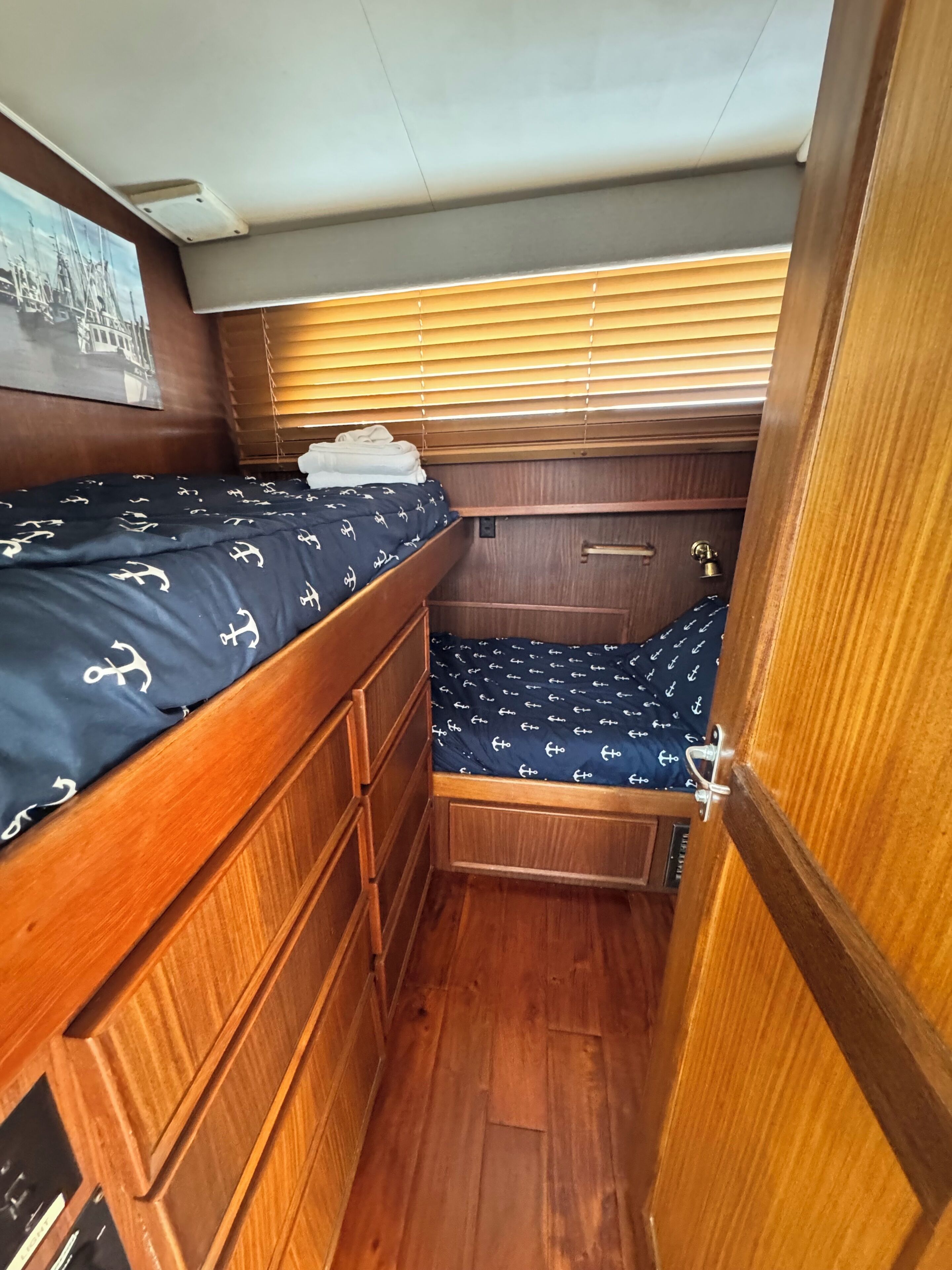 Una cabaña pequeña con una cama litera, muebles de madera y una ventana con persianas.