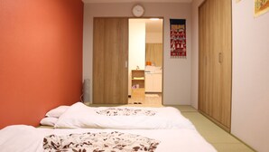 A bedroom with two beds, a wardrobe, a small bathroom, and a clock on the wall. - Shirakabanoyado-sakuragawa (Osaka)