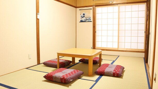 A traditional Japanese room with tatami flooring, a low wooden table, and cushions. - Shirakabanoyado-sakuragawa (Osaka)