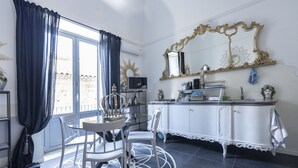 A dining area with a round table, chairs, a decorative mirror, and a cabinet with a white finish.