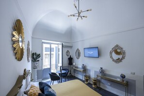 A bedroom with a bed, a desk, a chair, a television, and decorative mirrors. - I Mori (Catania)