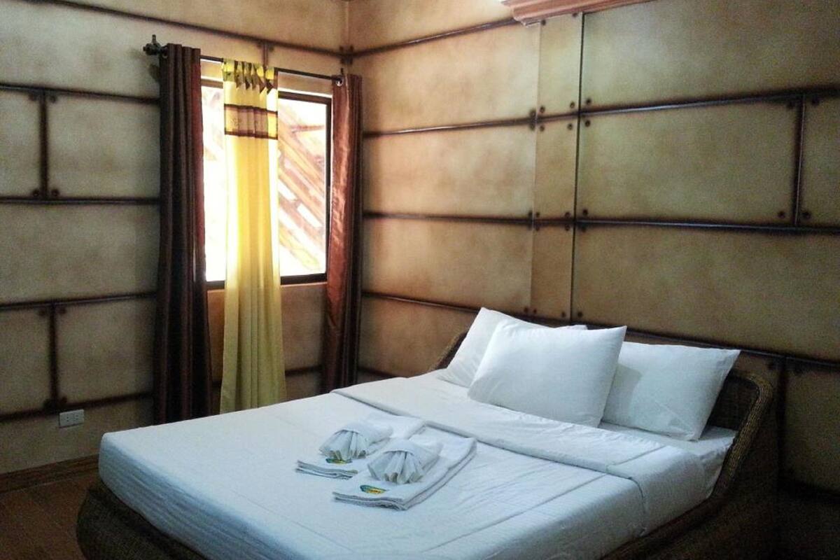 Une chambre d’hôtel avec un lit, des rideaux et une fenêtre.