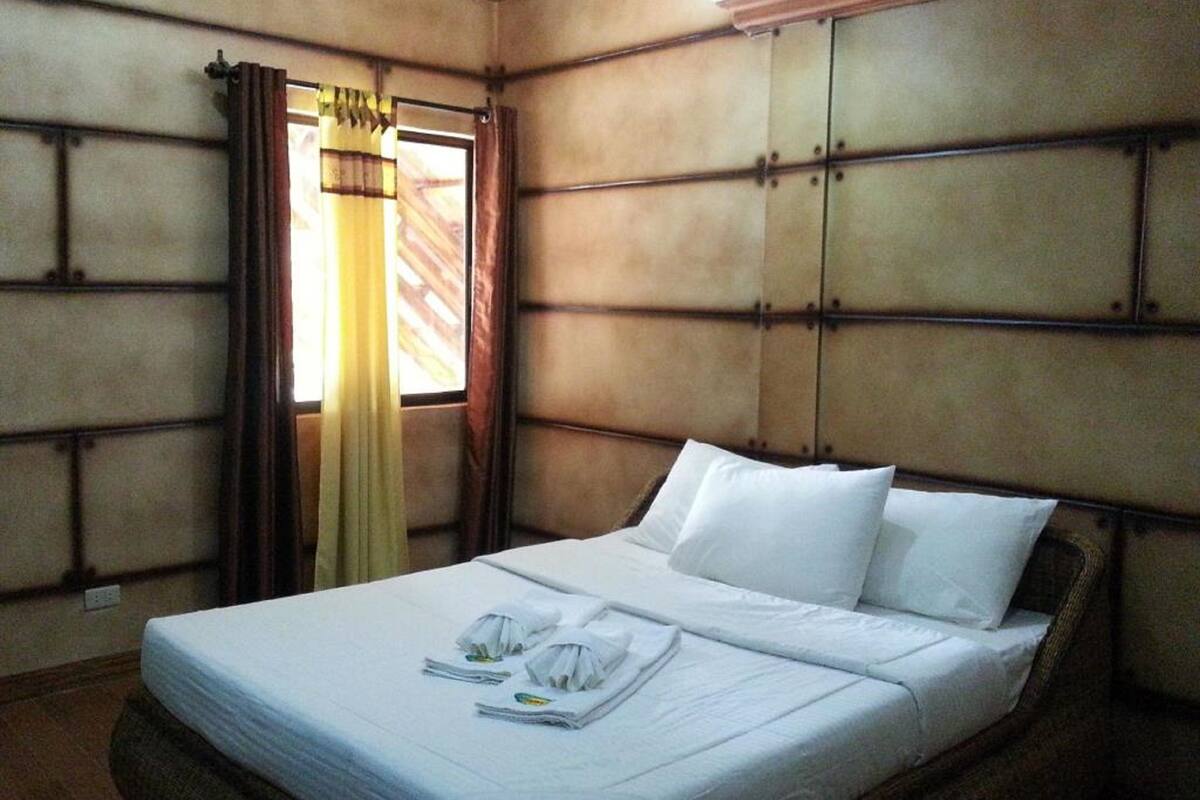Une chambre d’hôtel avec un lit, des rideaux et une fenêtre.