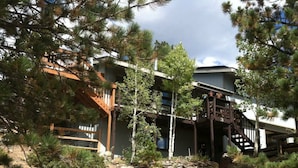 A rustic cabin with a wooden deck and a stone pathway leading to the entrance. - Nederland Dual Level Apartment, Full Kitchen, No Cleaning Fee, Private! (Nederland)