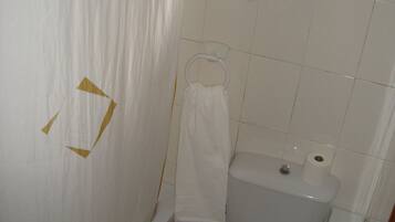 Un baño con bañera, inodoro y un perchero para toallas.