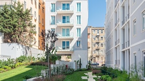 Un complejo de apartamentos moderno con un jardín bien cuidado y un sendero despejado.