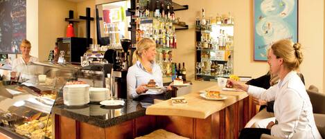 A bar area with a counter, shelves with bottles, and a chalkboard menu.