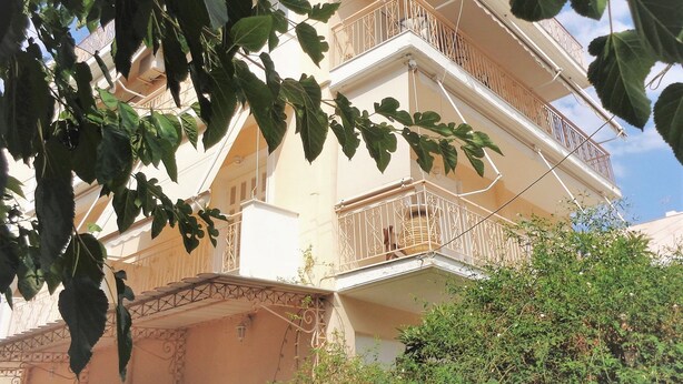A multi-story building with balconies, a balcony with a decorative railing, and a staircase leading to the upper floors. - Elena's House (Kalamata)