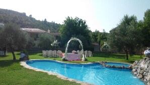 A swimming pool with a small island and a white archway. - Hotel La Alberquilla (Yeste)
