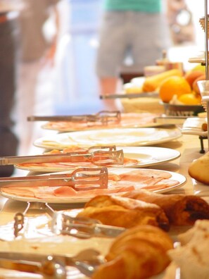 A buffet with various food items and utensils.