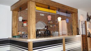 A kitchen with a brick wall, wooden beams, and hanging pendant lights. - Hotel La Alberquilla (Yeste)