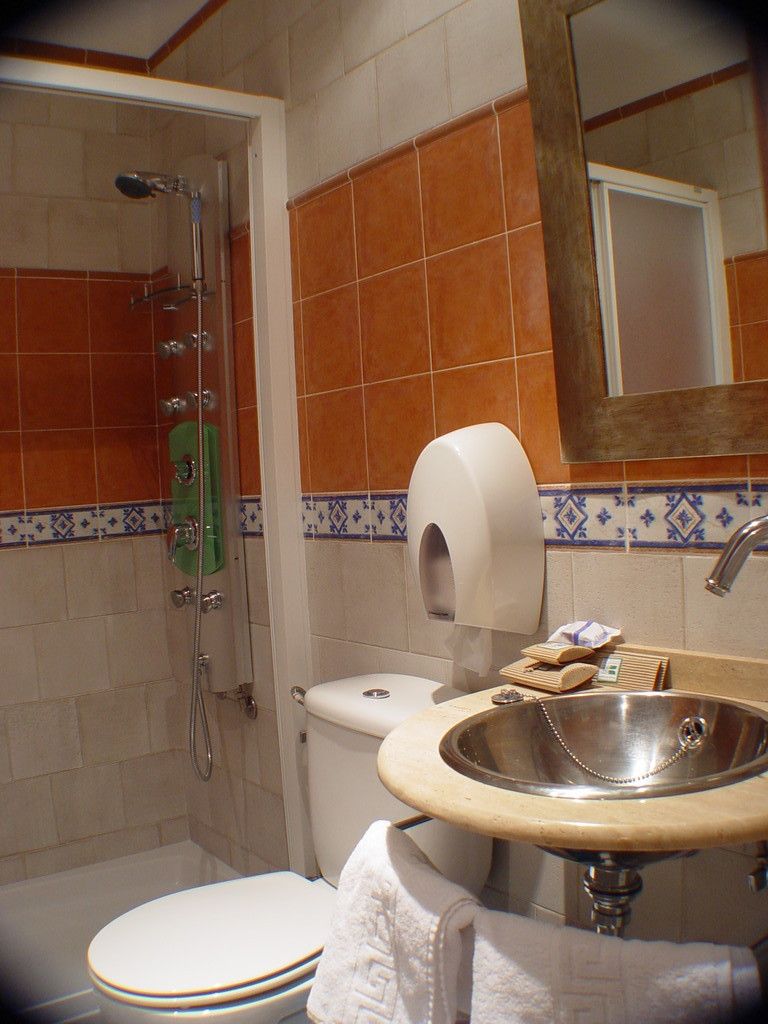 Ein Badezimmer mit Dusche, Toilette, Waschbecken und Handtuchhalter.