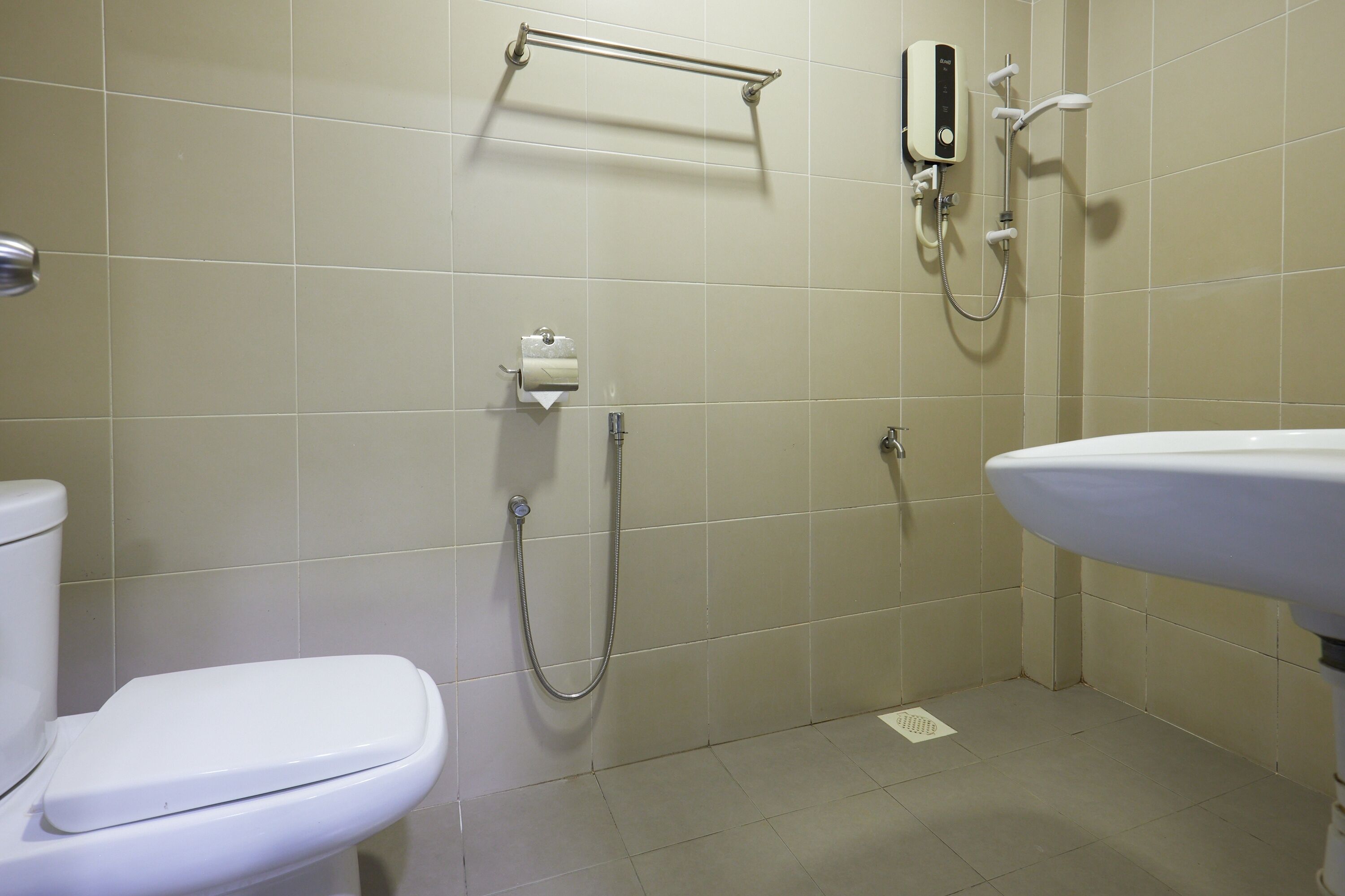 Une salle de bain avec des toilettes, un lavabo et une douche.