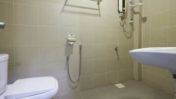 Une salle de bain avec des toilettes, un lavabo et une douche.