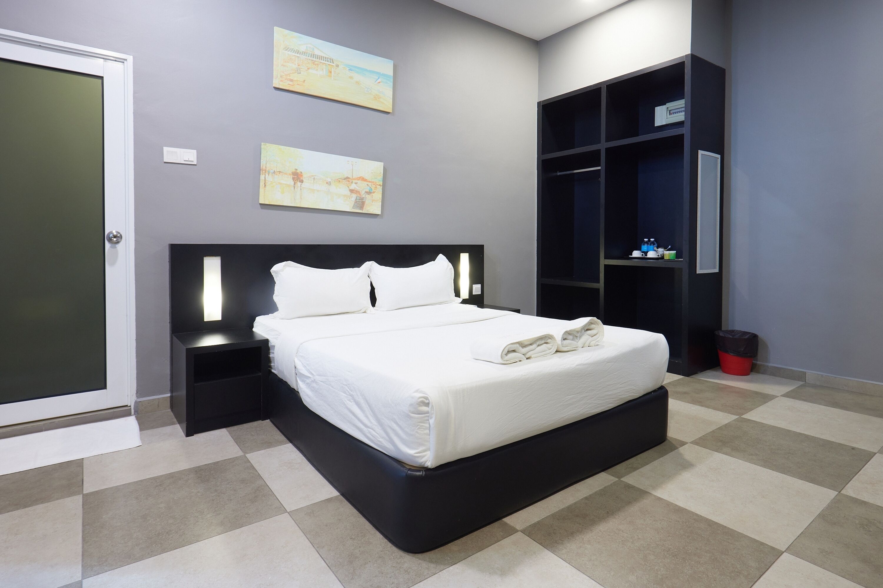 Un dormitorio moderno con cama, mesitas de noche, armario y una obra de arte en la pared.
