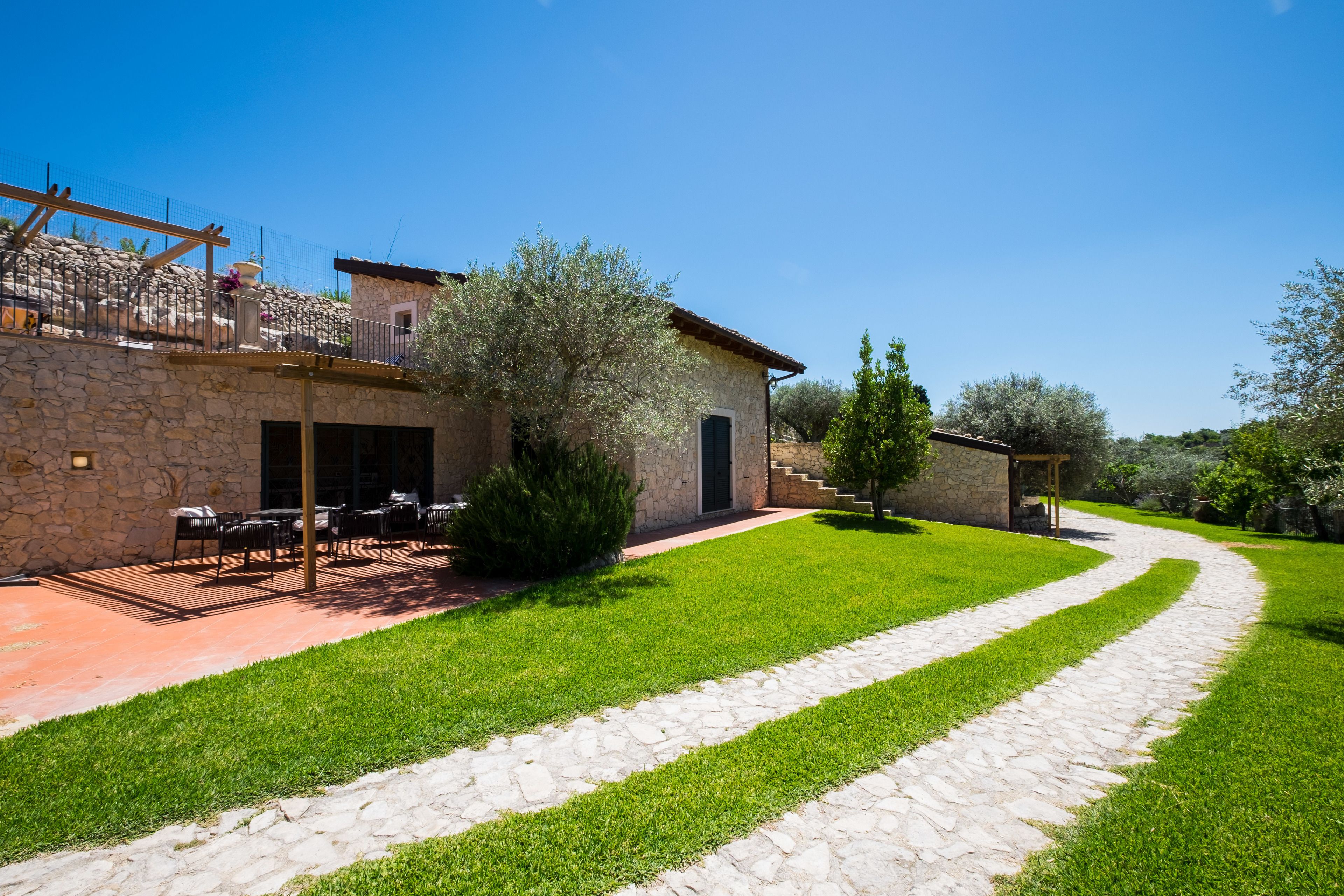 A stone building with outdoor seating and a stone pathway.