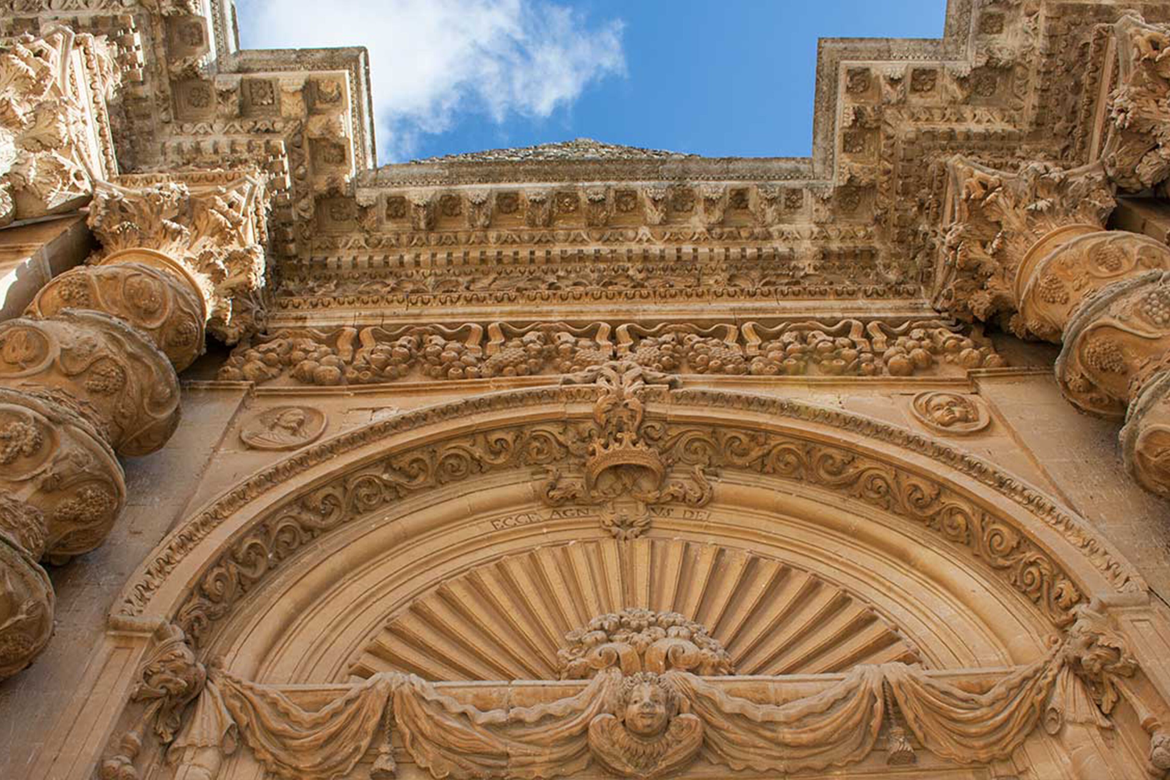 A detailed stone facade with intricate carvings and a central archway.
