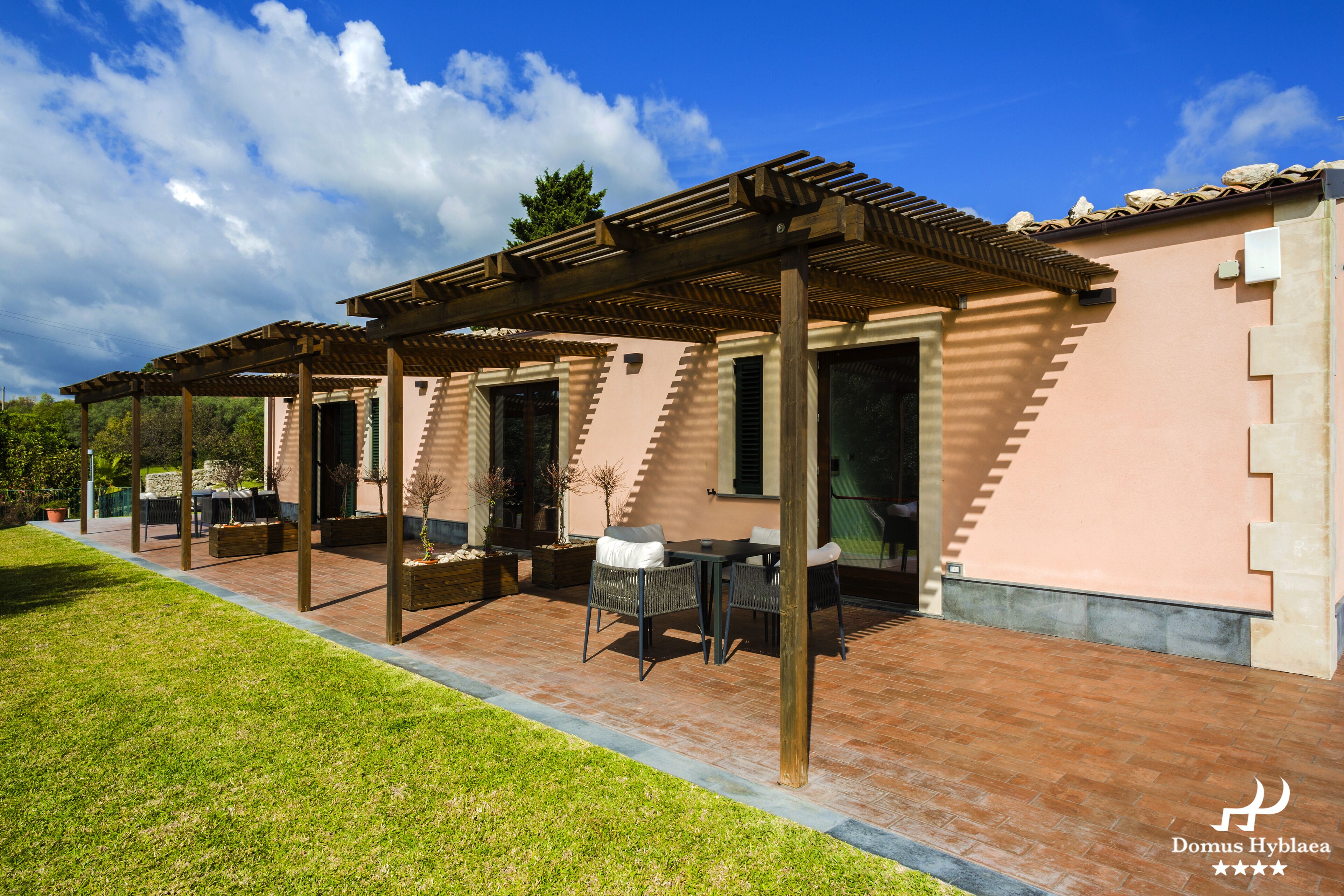 A covered patio area with outdoor furniture and a pergola structure.