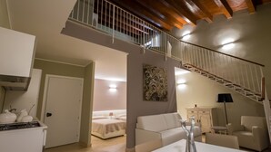 A modern living room with a staircase, a dining area, and a kitchen. - Domus Hyblaea (Palazzolo Acreide)