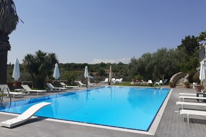Piscine extérieure en saison, chaises longues