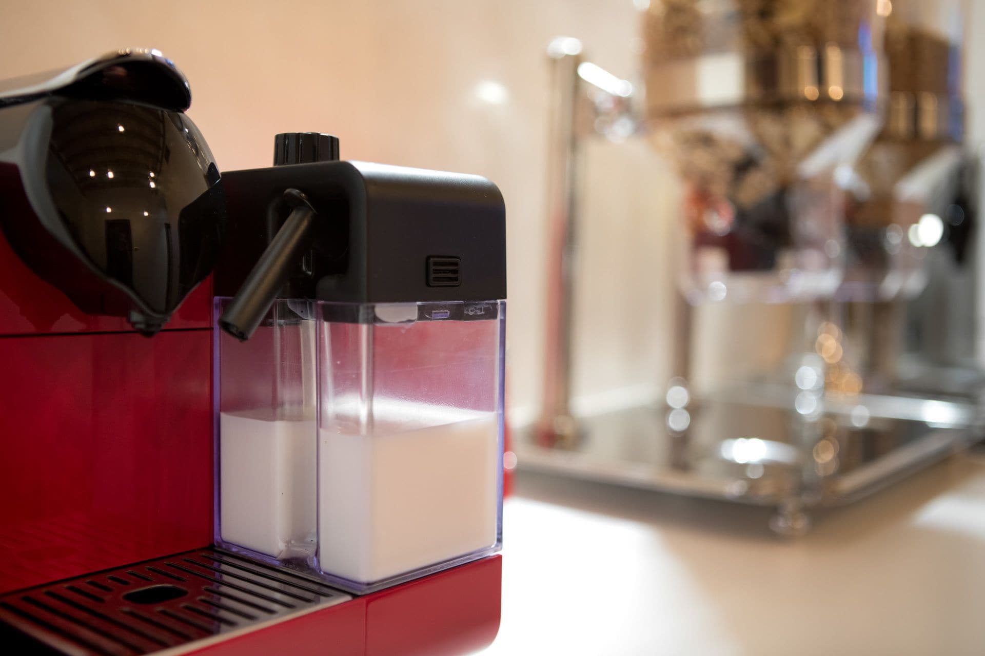 A coffee machine with a milk frother and a water reservoir.
