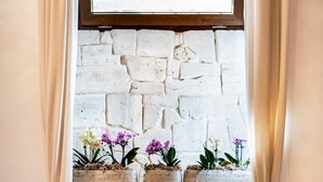 A stone fireplace with a wooden mantel, flanked by beige curtains, and above it, a window with a grid pattern. - Lighthouse Suites Trastevere (Rome)