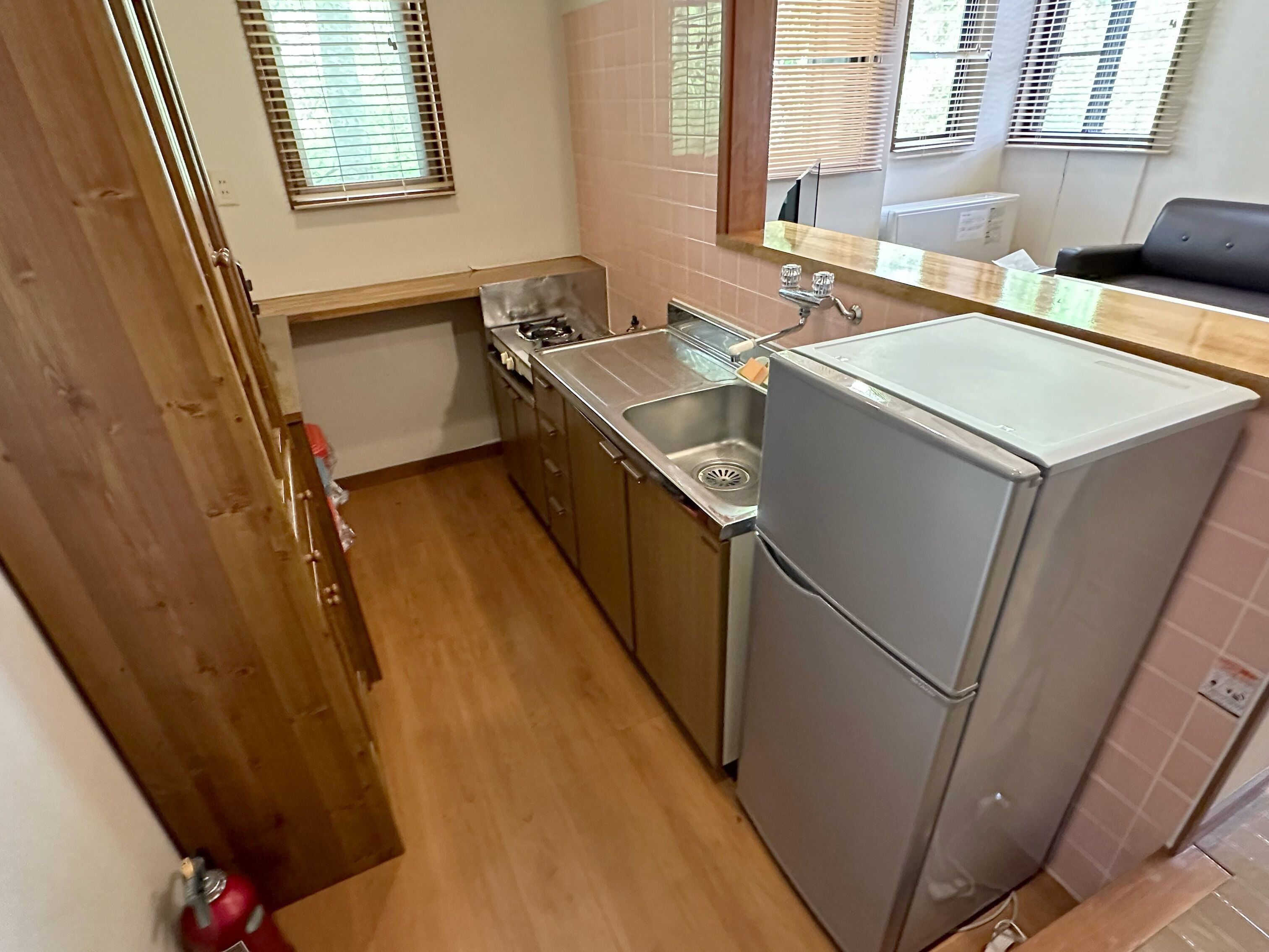 Una cocina pequeña con lavabo, estufa y refrigerador.