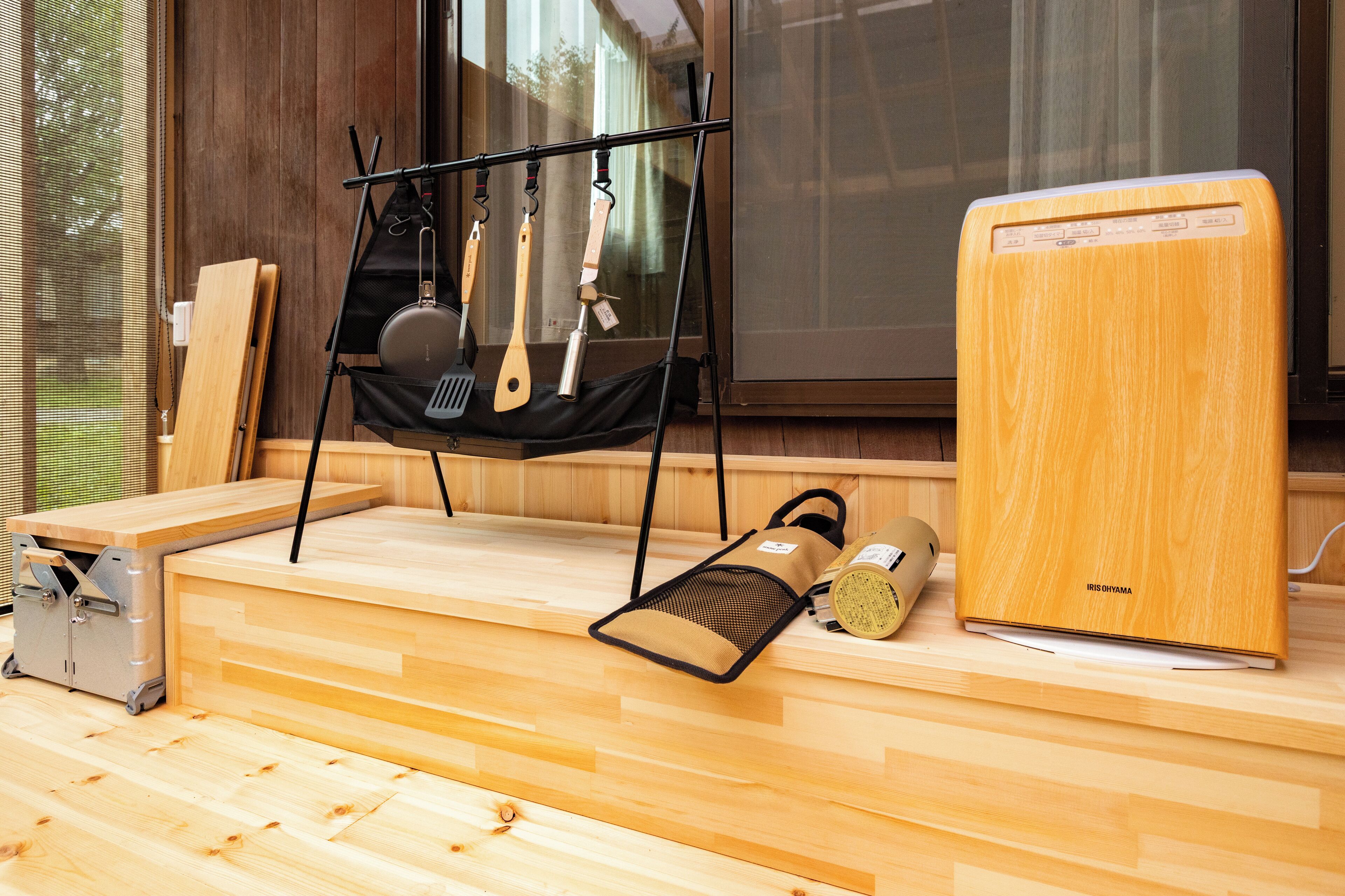 A wooden room with a bed, a small table, and a window.