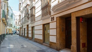 A narrow street with buildings on either side, including a building with the number 21. - La Sorpresa del GENOVES by Cadiz4Rentals (Cádiz)