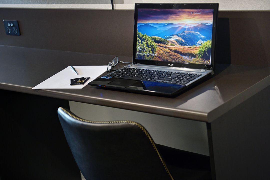 Una computadora portátil sobre un escritorio, con un bolígrafo y un teléfono inteligente.