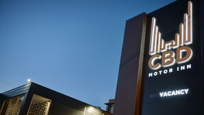 A sign for CBD Motor Inn with a 'NO VACANCY' message.