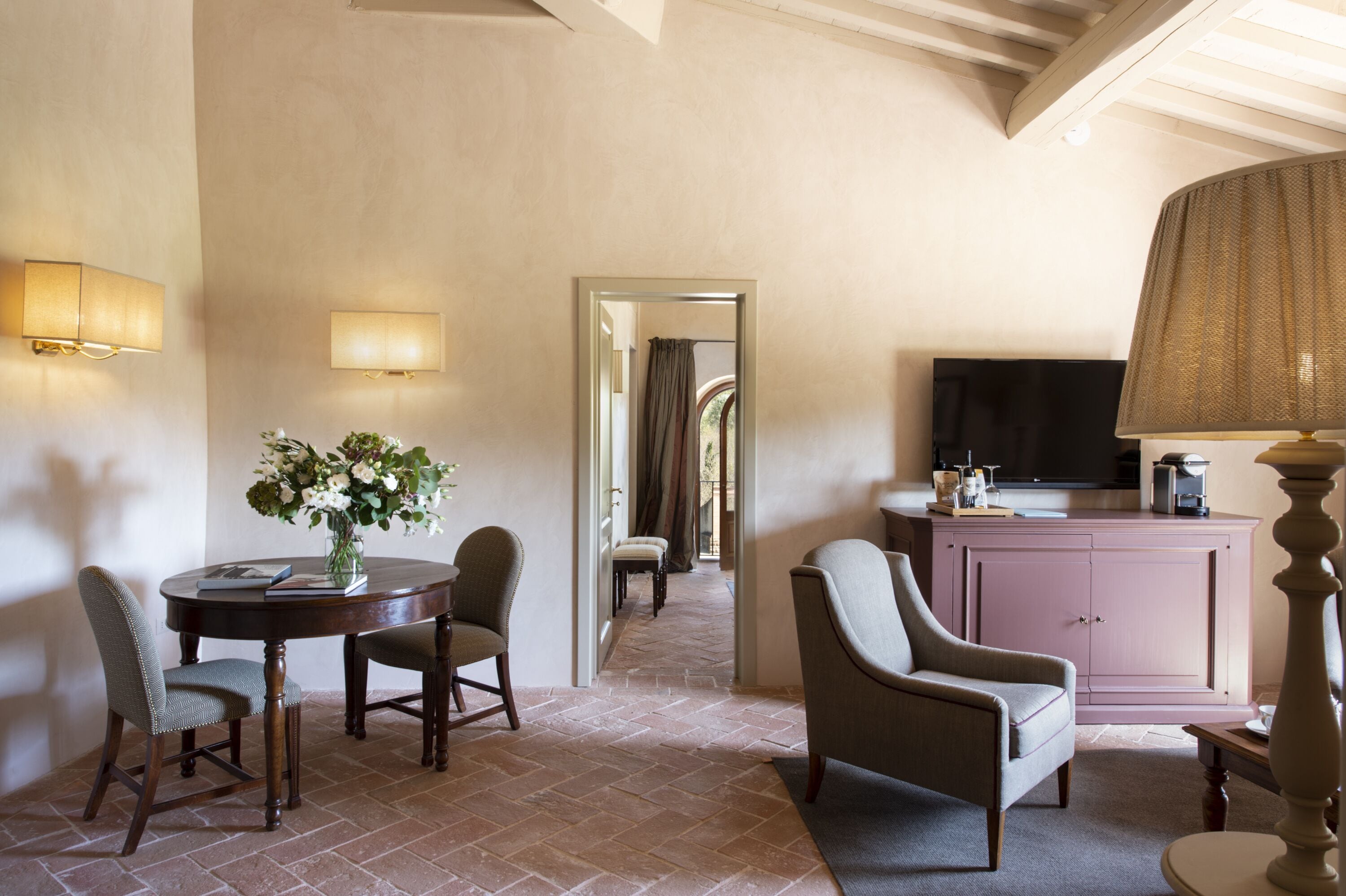Habitación de hotel con comedor, televisor y mueble.