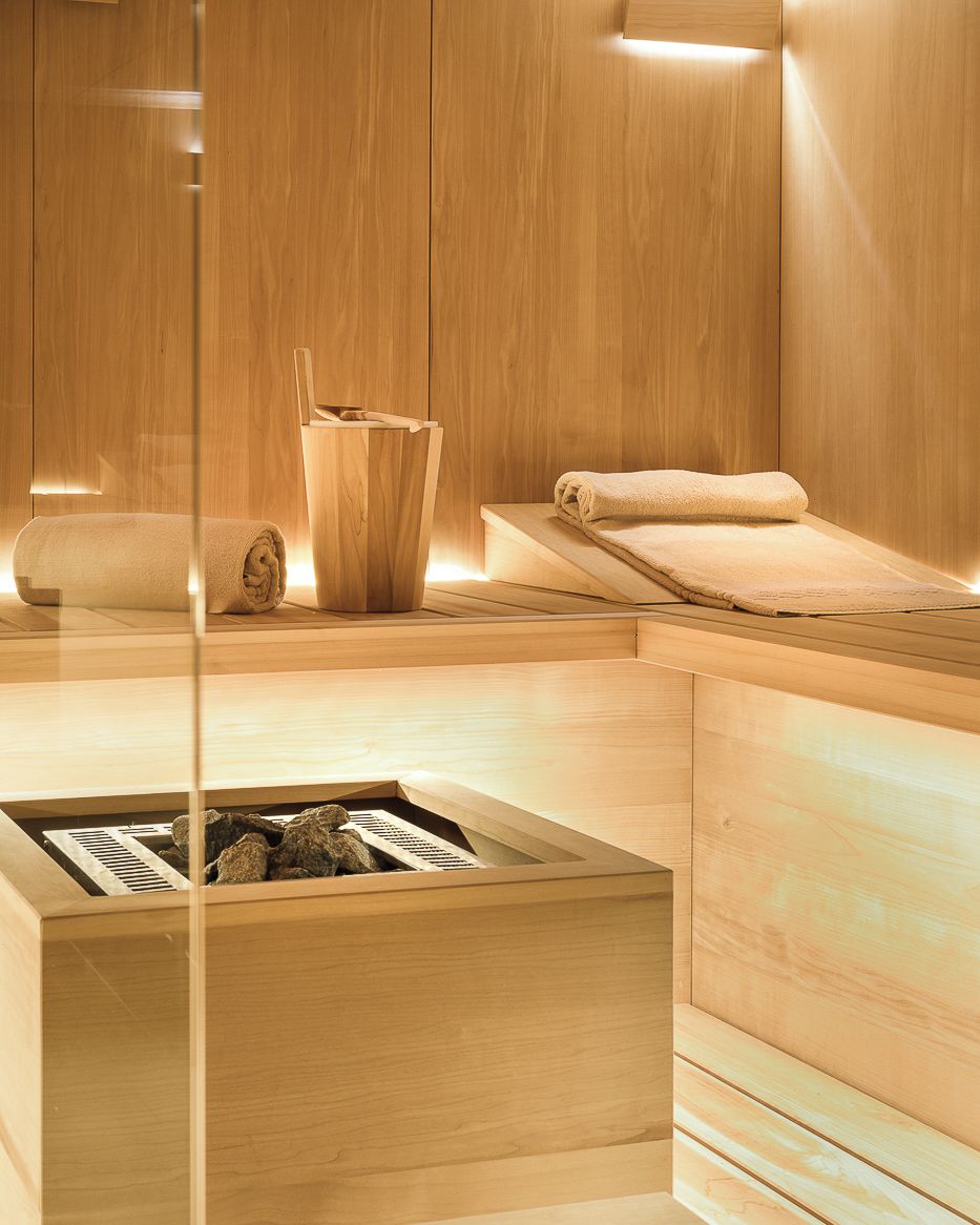 Un espace de détente en bois comprenant un bain à remous, des serviettes et une structure en bois agrémentée de rochers.
