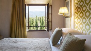 Une chambre à coucher avec un lit, une fenêtre avec des rideaux, une lampe et un mur décoré d’un motif.