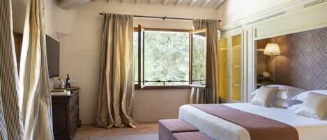 Quarto com uma cama grande, mesa de cabeceira, espelho e janela com cortinas.