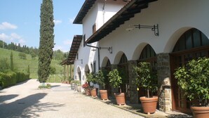 A traditional building with a white facade, terracotta roof tiles, and arched windows. - Agriturismo Colutta (Manzano)
