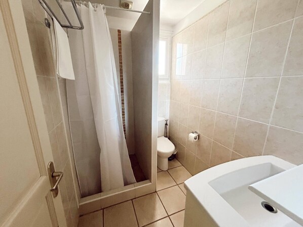 A bathroom with a shower, toilet, and bathtub.