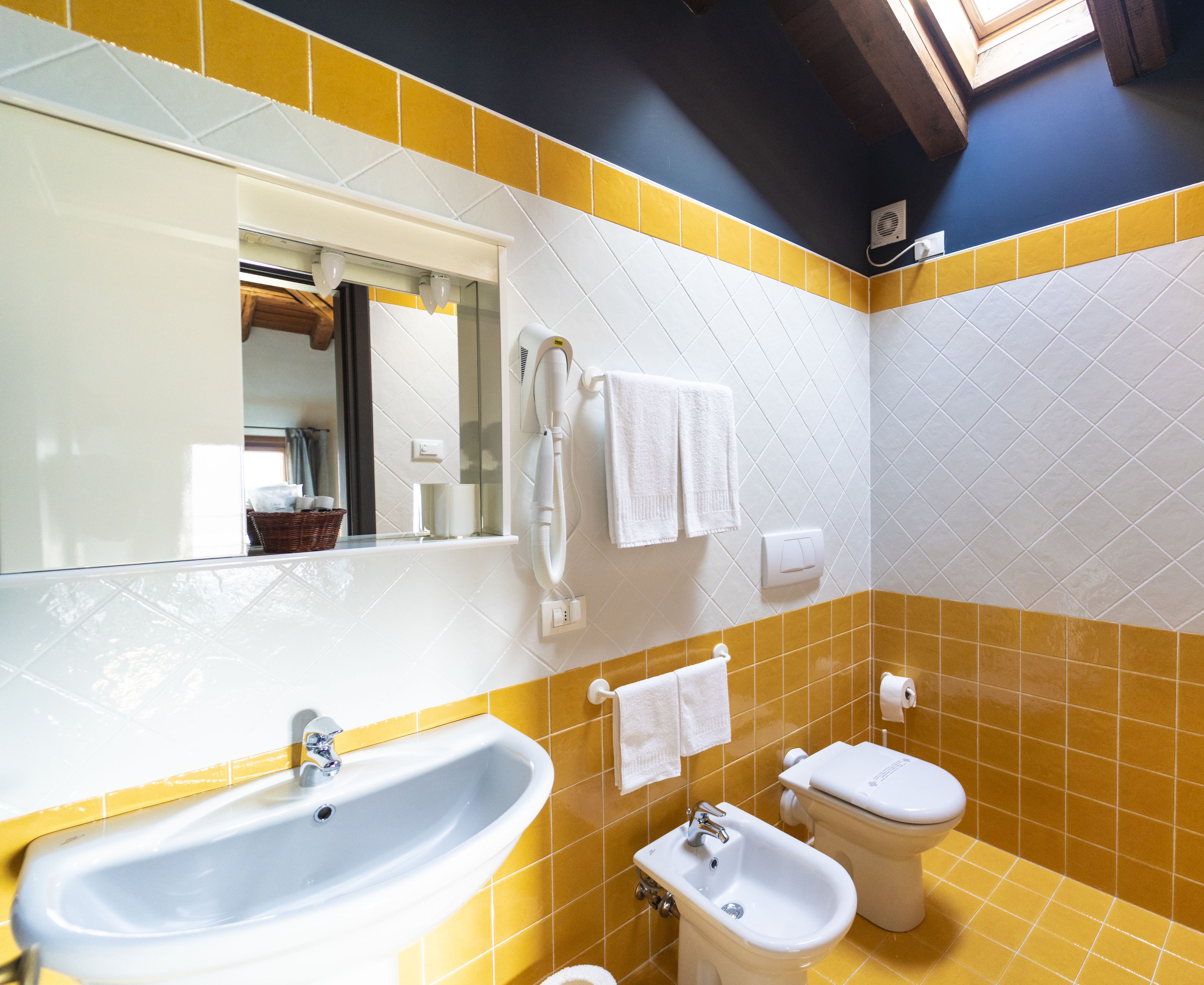 A bathroom with a sink, bidet, toilet, and a mirror.