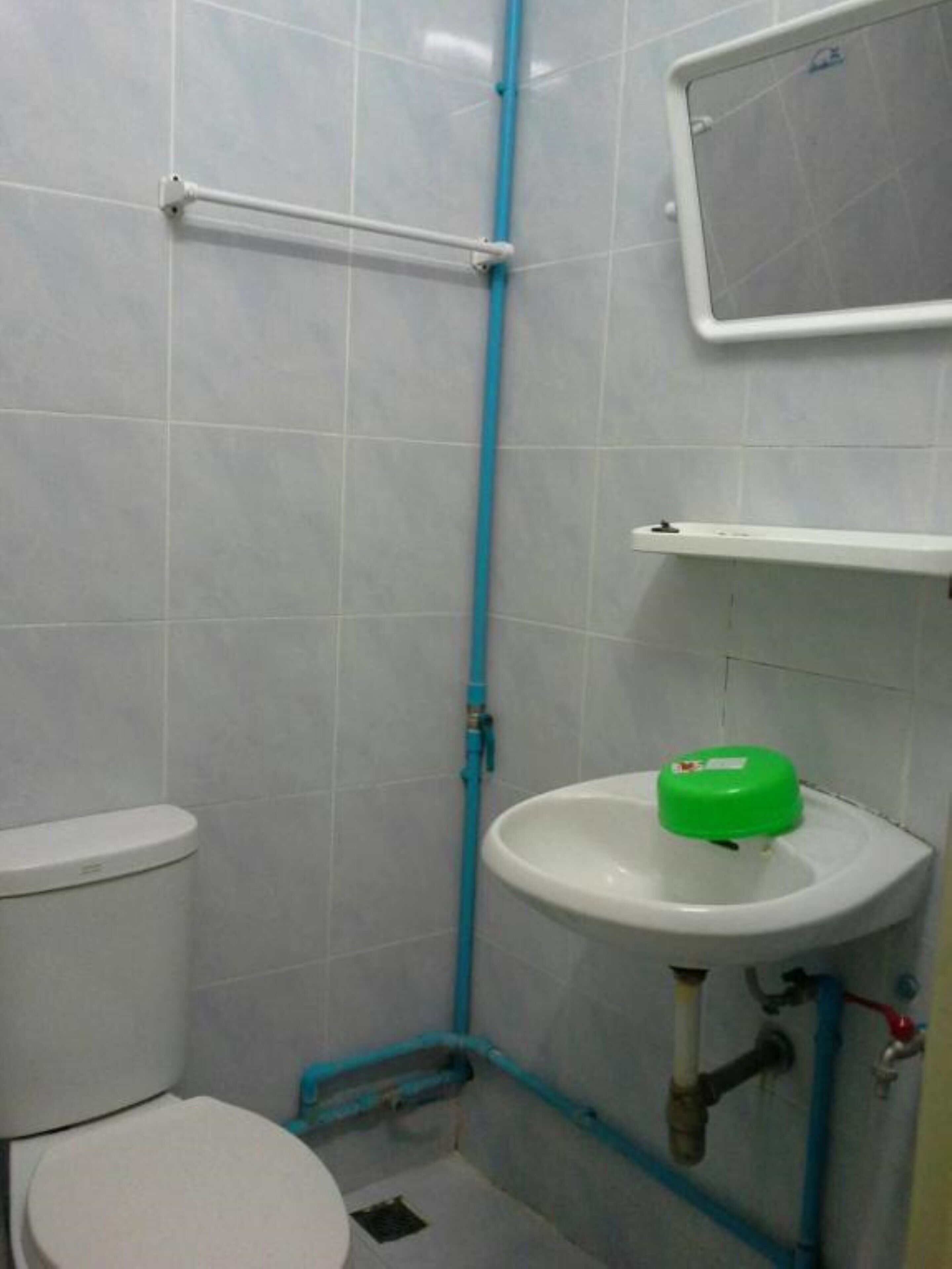 A small bathroom with a toilet, a sink, and a shower area.