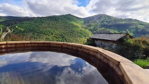 A wooden deck with a clear view of a mountain landscape, a rustic building, and a tree. - El Bosque de las Viñas (Boal)