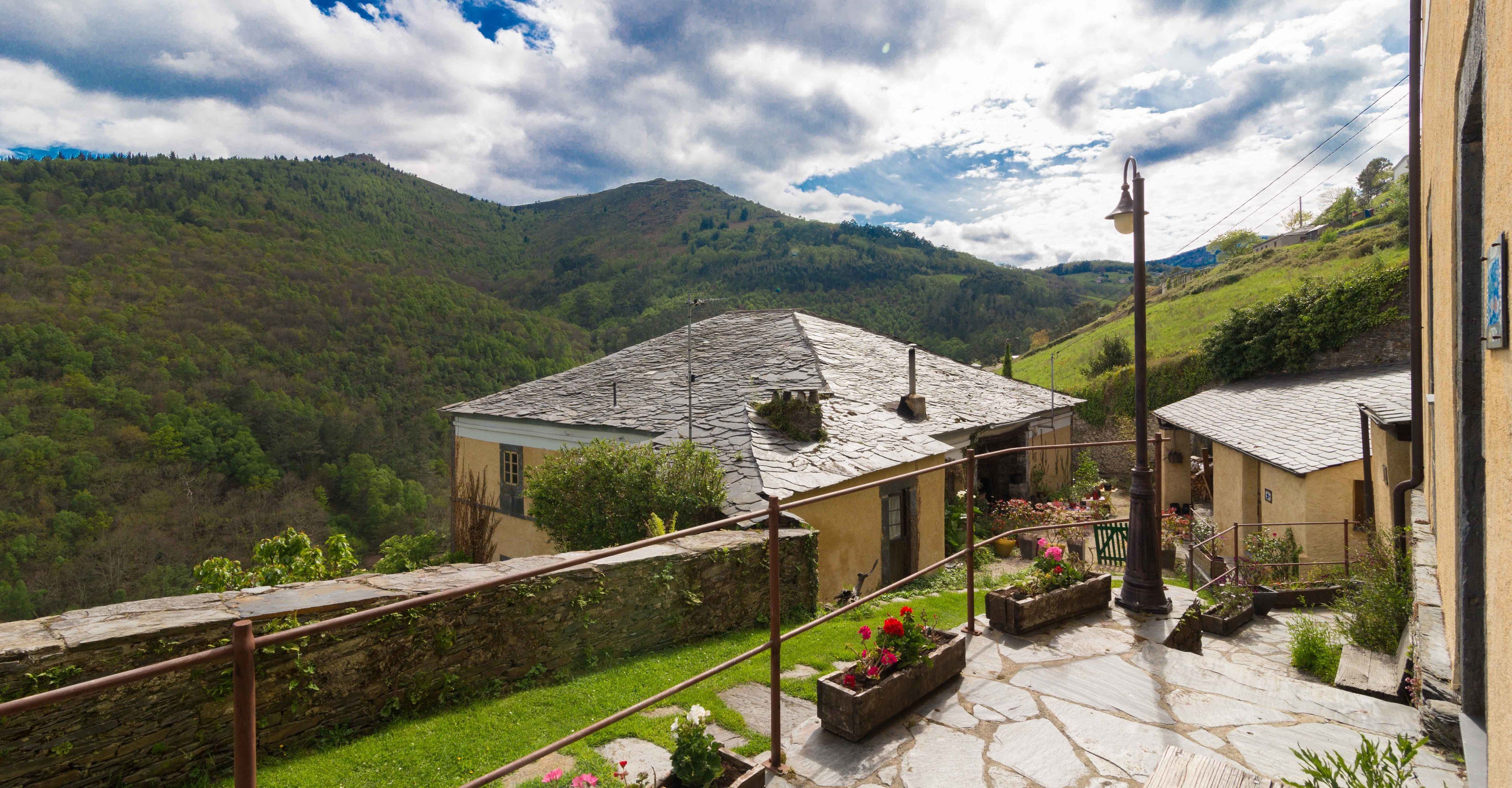 A stone staircase leading to a terrace with a view of a mountain landscape.