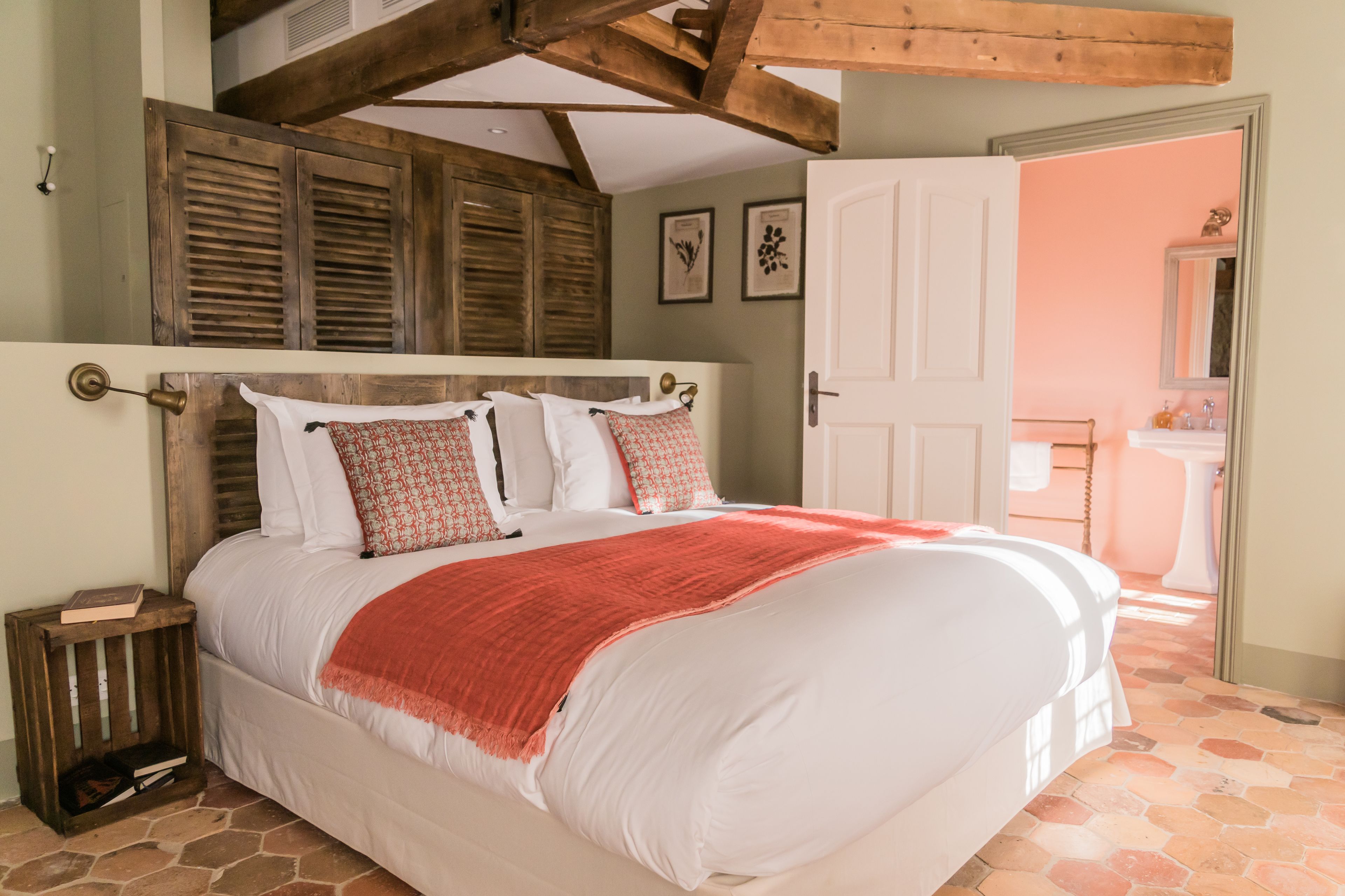 Una camera da letto con un letto grande, una testiera in legno e una coperta rossa.