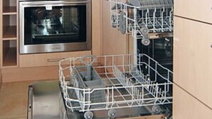 A kitchen with a built-in dishwasher, an oven, and a coffee maker. - Vacation home Nicole - Holiday homes Friesensterne (Esens)