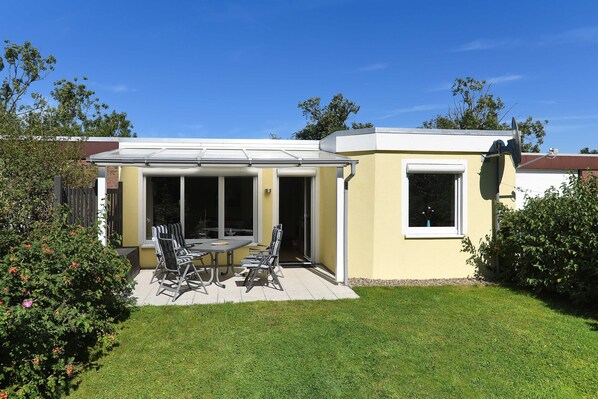 A house with a patio, a dining table, and chairs.