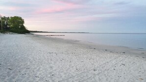 En strand med en sandstrand och ett lugnt hav.