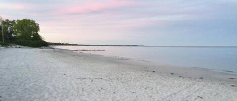 A beach with a sandy shore and a calm sea.