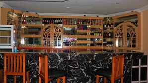 Una zona de bar con encimeras de mármol y sillas de madera.