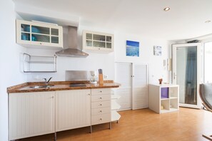 A modern kitchen with white cabinetry, a granite countertop, a stainless steel range hood, and a built-in oven. - Modern Holiday Apartment "Arena" With Sea View (Conil de la Frontera)