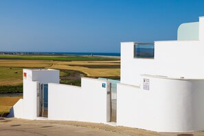 Un edificio blanco con vistas a un paisaje costero.