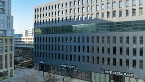 A modern building with multiple floors, featuring a prominent 'Vatel School' sign and a 'Vatel Restaurant' sign. - Appart’hôtel Odalys City - Nantes Cité des congrès (Nantes)